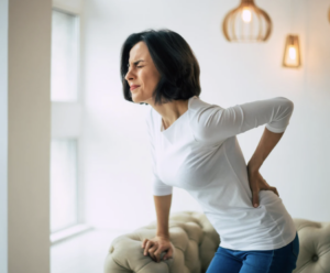 Woman holding onto her back in pain